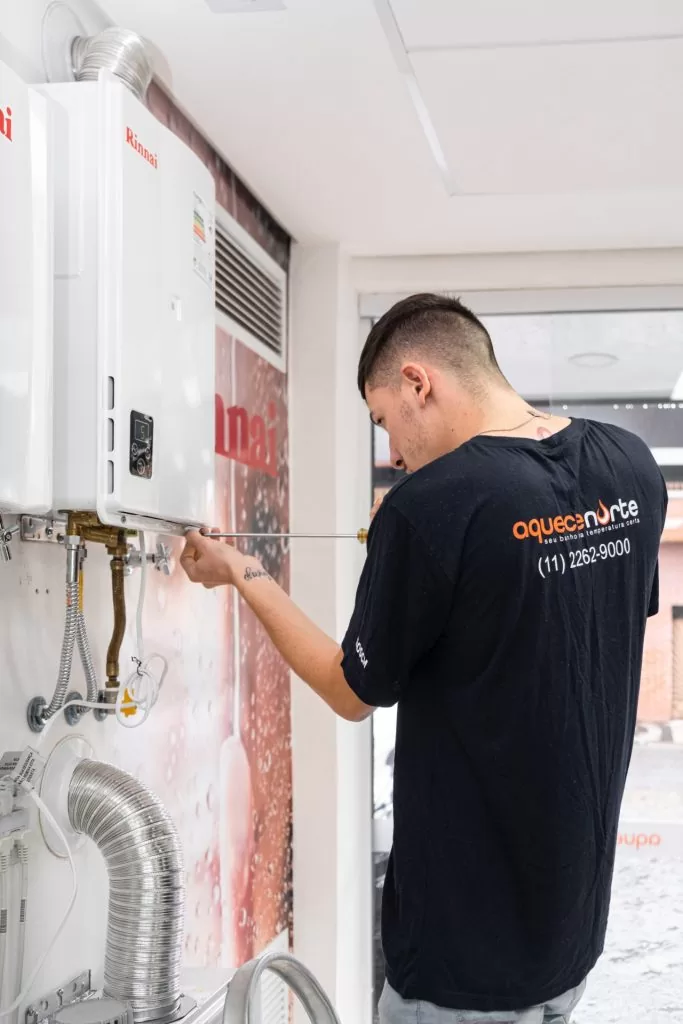 profissional da Norte Aquecedores resolvendo problema de aquecedor a gás saindo pouca água